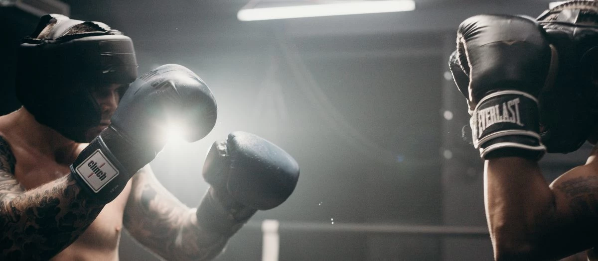  boxeador con guantes de boxeo negros en posición de ataque